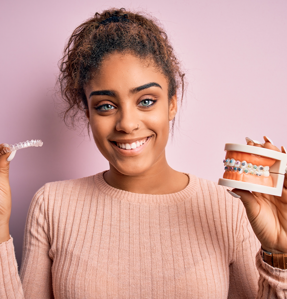 clear aligner being held with braces
